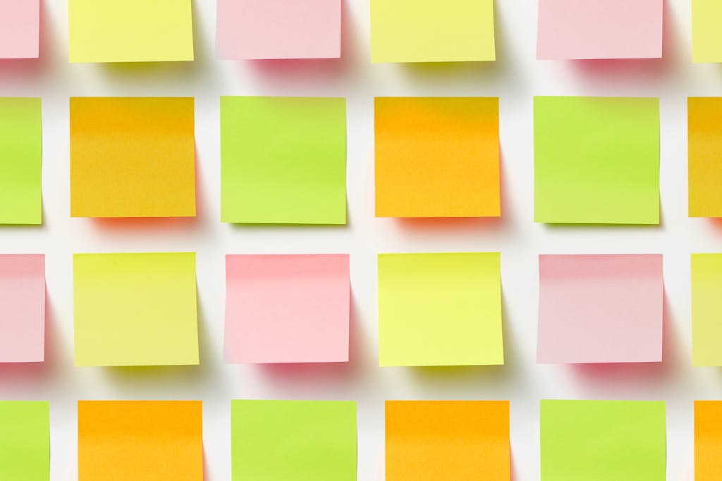 Grid of colorful sticky notes creating a vibrant pattern on a white surface.